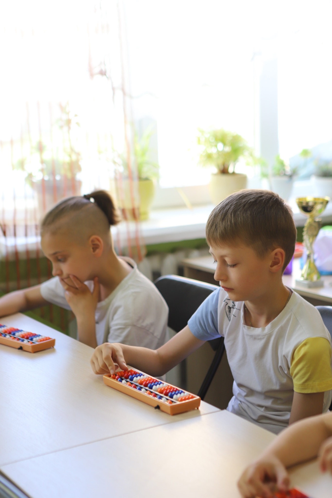 Children practising with an abacus during a real lesson